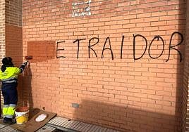 Un operario procede a la limpieza de una pintada contra el PSOE