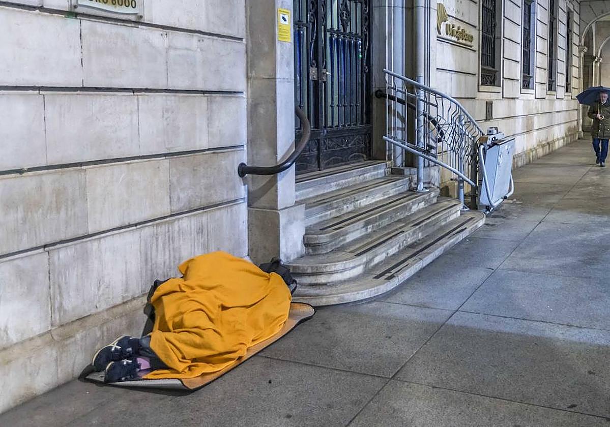 Imagen de archivo de una persona en situación de sin hogar durmiendo en el suelo.