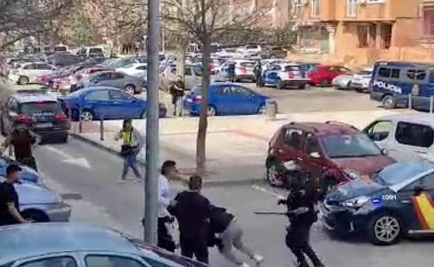 Momento en que un policía repele el ataque de varios vecinos del presunto homicida en un barrio de Toledo.