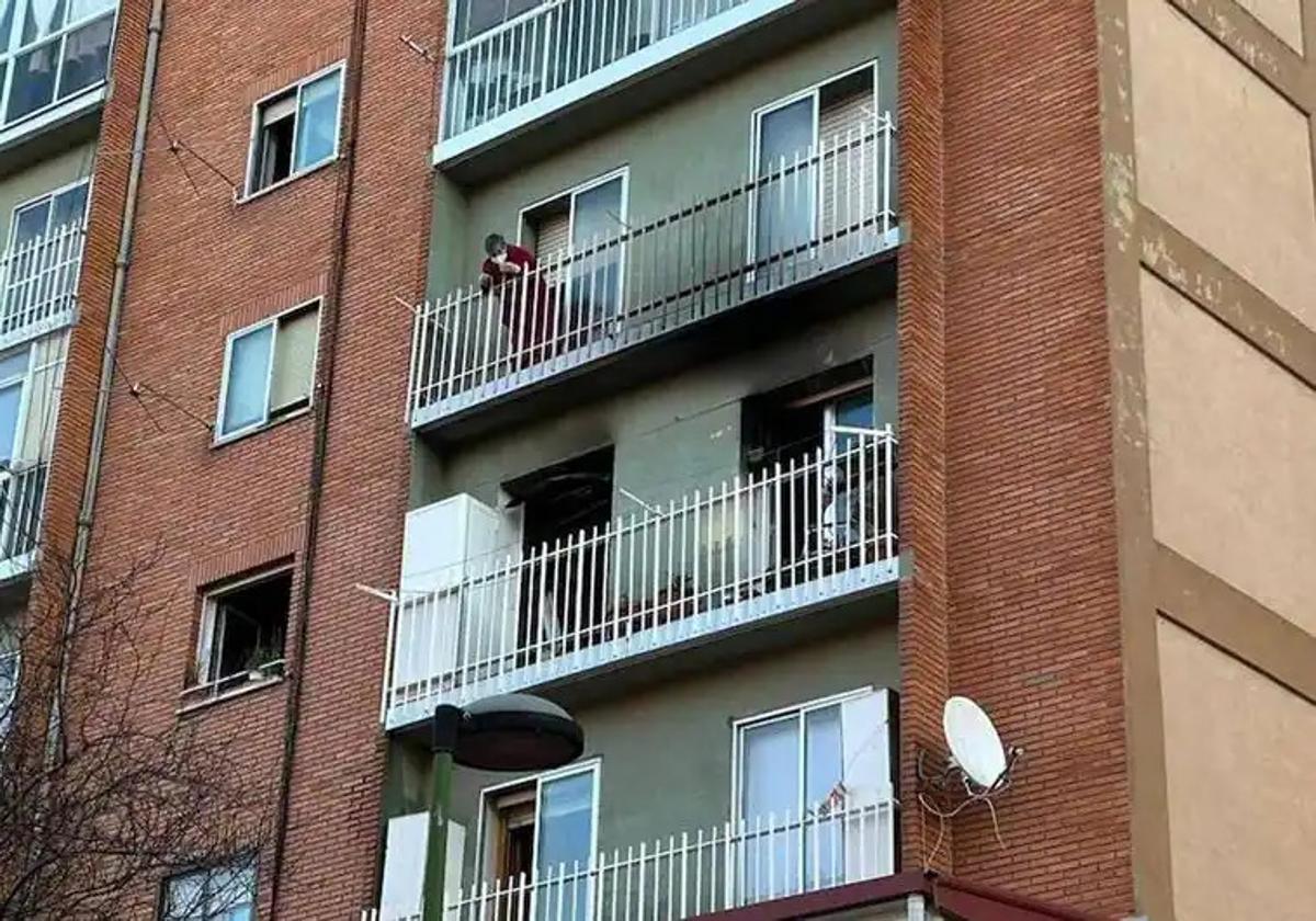 La vecina del cuarto piso observa la vivienda del tercero donde ha ocurrido el incendio.