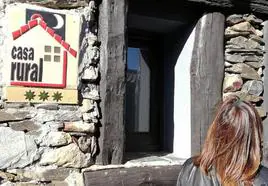 Imagen de archivo de una turista frente a una casa rural