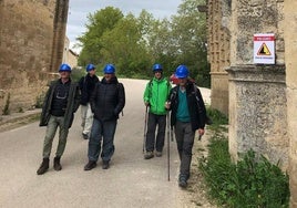 Peregrinos con casco pasando por las ruinas del convento de San Antón, en Castrojeriz.