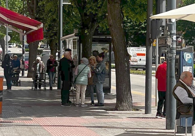 Corrillos en acera de enfrente del lugar del suceso.