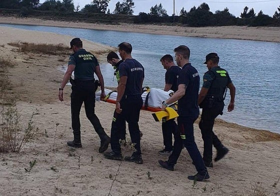 Guardia Civil y Bomberos portan el cuerpo del menor fallecido en el pantano de Arija por el síndrome de inmersión.