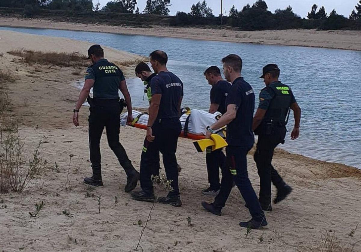 Guardia Civil y Bomberos portan el cuerpo del menor fallecido en el pantano de Arija por el síndrome de inmersión.