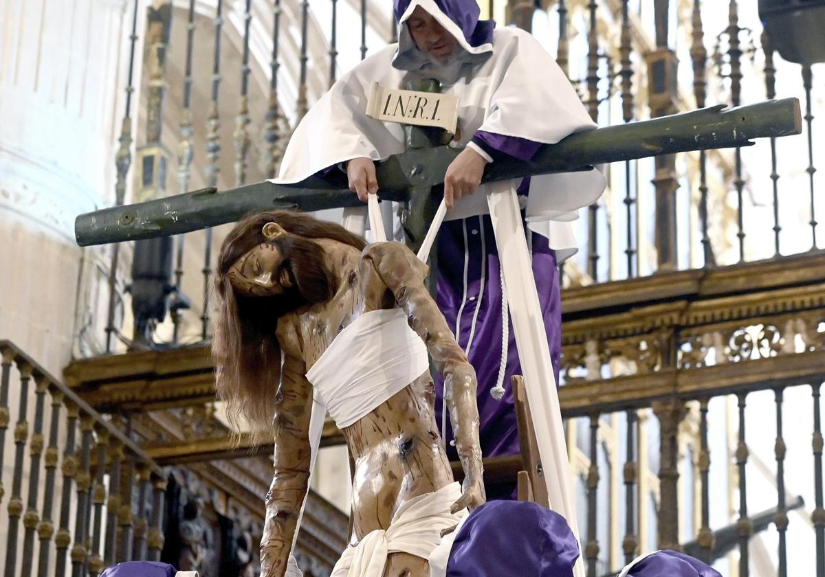 Los cofrades de las Siete Palabras descienden al Cristo de Burgos.