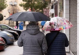 Una pareja se protege de la lluvia.