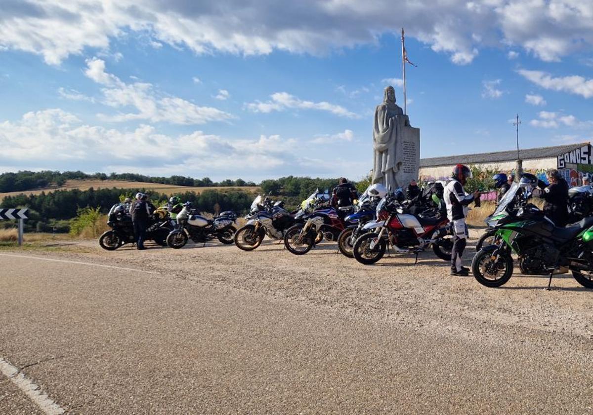 Imagen principal - Arriba, motoristas junto a la Estatua del Cid en Mecerreyes; abajo, a la izquierda, en el Arco romano de Medinaceli y a su lado en la plaza Mayor de Sigüenza, Guadalajara.