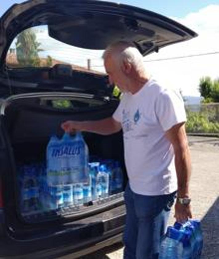 Imagen secundaria 2 - Dos vecinos recogían agua embotellada de la Casa del Concejo cuando no podían consumir la del grifo. 