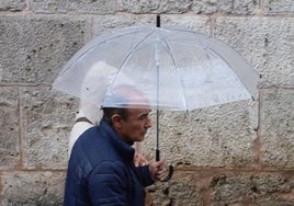 Una pareja se protege de la lluvia con un paraguas.