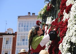 Chica poniendo las flores a la escultura realizada para la Ofrenda Floral de los Sampedros