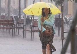 Una mujer en medio de una tromba de agua.