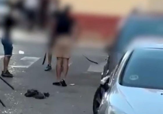 Momento del vídeo de la multitudinaria pelea de Aranda, en el fotograma se ve a dos personas con sus cinturones en la mano para agredir al otro.