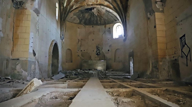 Interior de la iglesia del pueblo abandonado con las tumbas saqueadas.