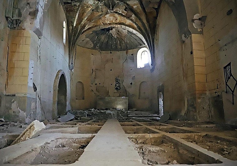 Interior de la iglesia del pueblo abandonado con las tumbas saqueadas.