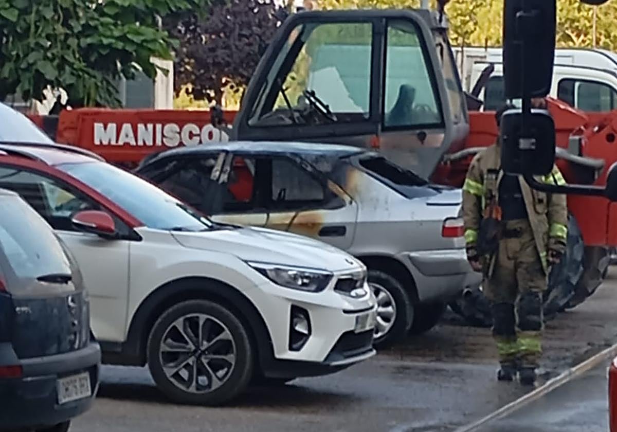 Los Bomberos de Aranda trabajan en el lugar del coche incendiado.