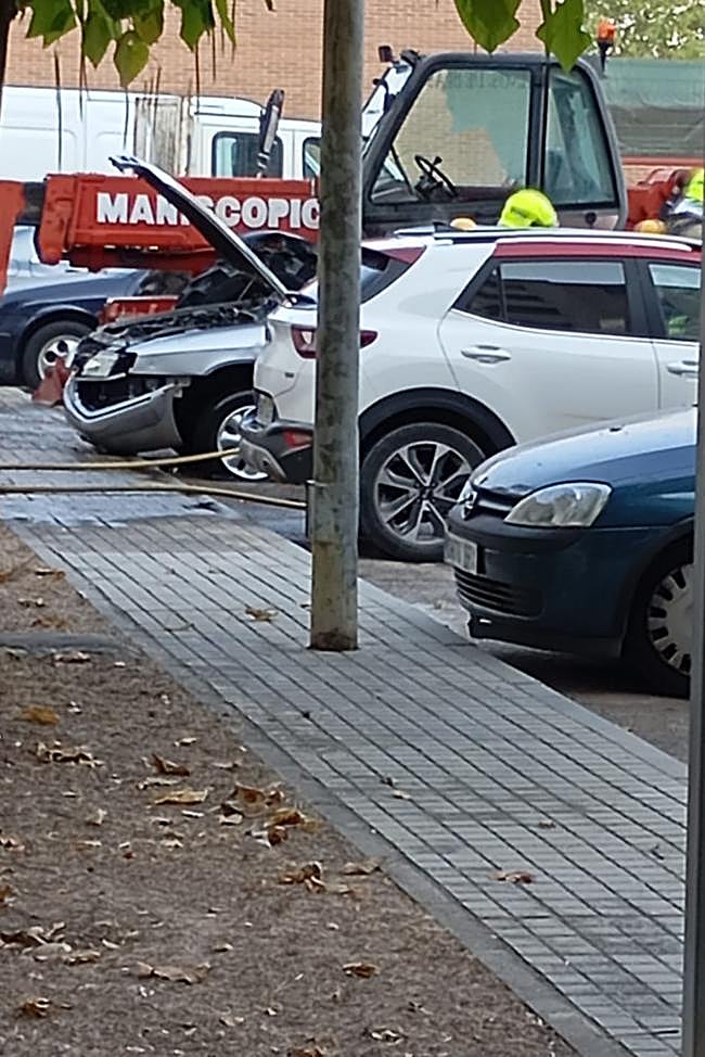 Los Bomberos trabajan en el coche incendiado en Aranda.