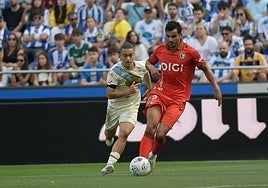 Florian Miguel conduce un balón persiguido por el deportivista Luismi Cruz