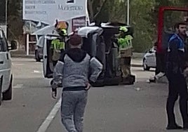 Bomberos de Aranda de Duero y Policía Local junto al turismo volcado a la entrada del hotel Montermoso.