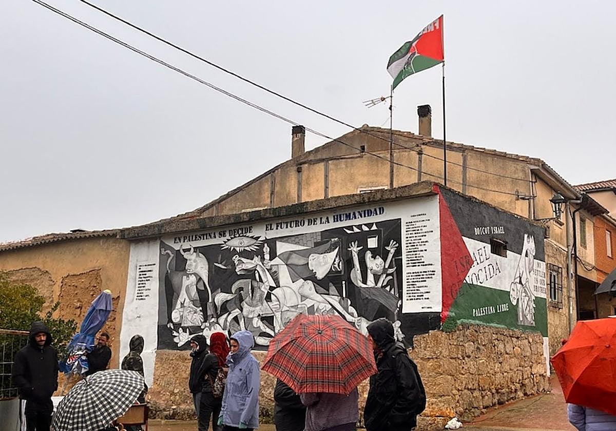 Un grupo de personas frente a la esquina de la nave con el doble mural.