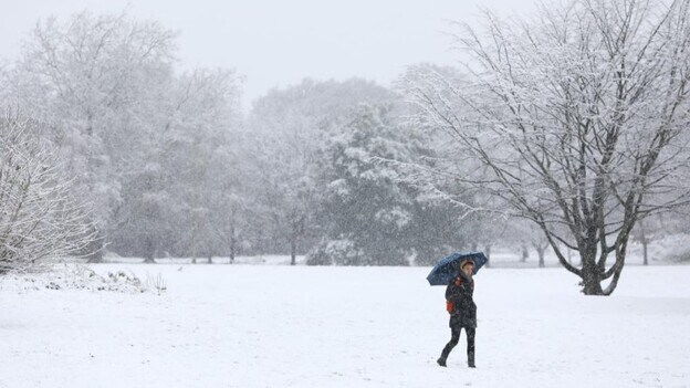 Una persona intenta protegerse de la nieve en el norte de Londres. / Efe