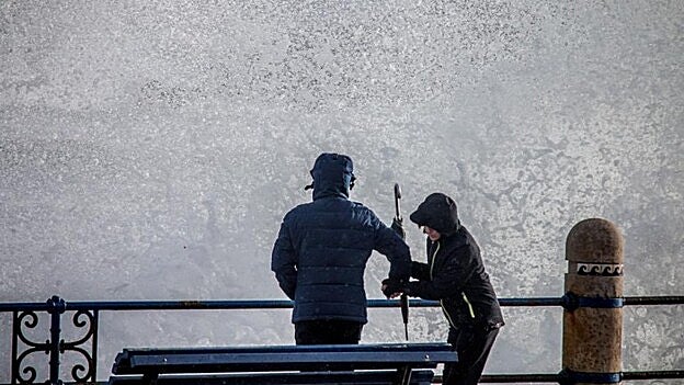 Olas y frío en el paseo marítimo de Santander. / Efe