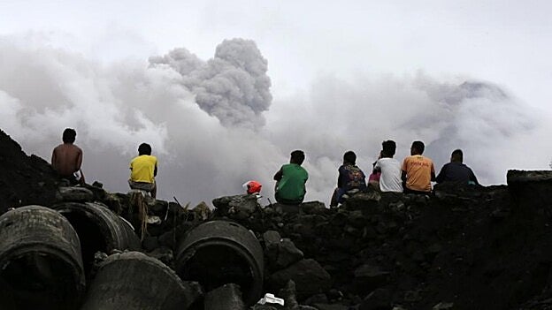 Jóvenes filipinos observan las cenizas que desprende el volcán /  Efe