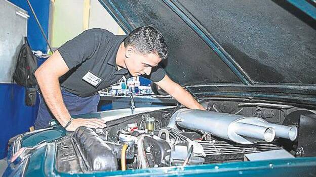 Aythami Díaz revisa un motor antiguo, pura artesanía.