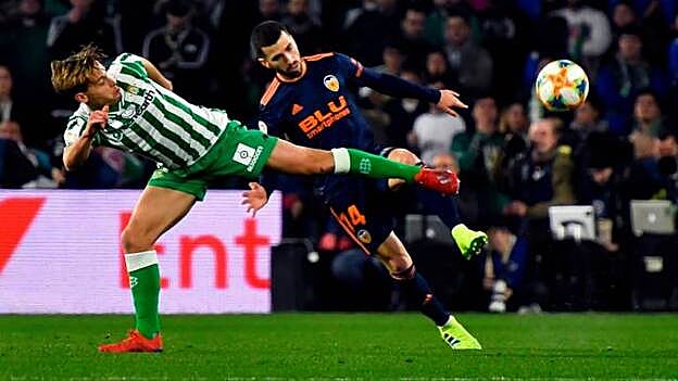 El centrocampista del Betis Sergio Canales (i) pelea un balón con el defensa del Valencia José Gayá, en una jugada del partido de ida de semifinales de la Copa del Rey que los dos equipos juegan esta noche en el estadio Benito Villamarín. / Efe.