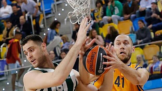 El jugador del Herbalife Gran Canaria Kim Tillie (d) y el jugador del Panathinaikos Giorgios Papagiannis (i) durante el partido de la Euroliga. / Efe.