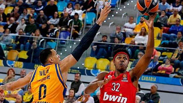 El alero estadounidense del Olympiacos, Zach LeDay (d), intenta encestar ante la defensa de su compatriota, el jugador del Herbalife Gran Canaria, Jacob Wiley, durante el partido de Euroliga disputado este jueves en el Gran Canaria Arena, en Las Palmas de Gran Canaria. / Efe.