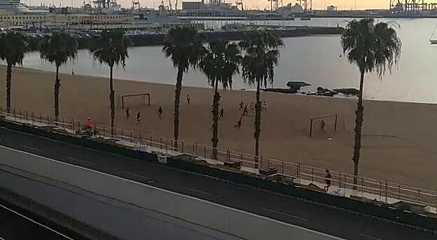 Jugando al fútbol todos juntos en la playa