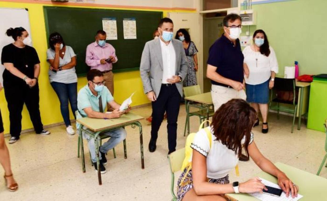 La presentación del plan tuvo lugar en un aula del colegio Esteban Navarro, en El Calero. Alcalde y edil acceden entre periodistas sentados en pupitres.