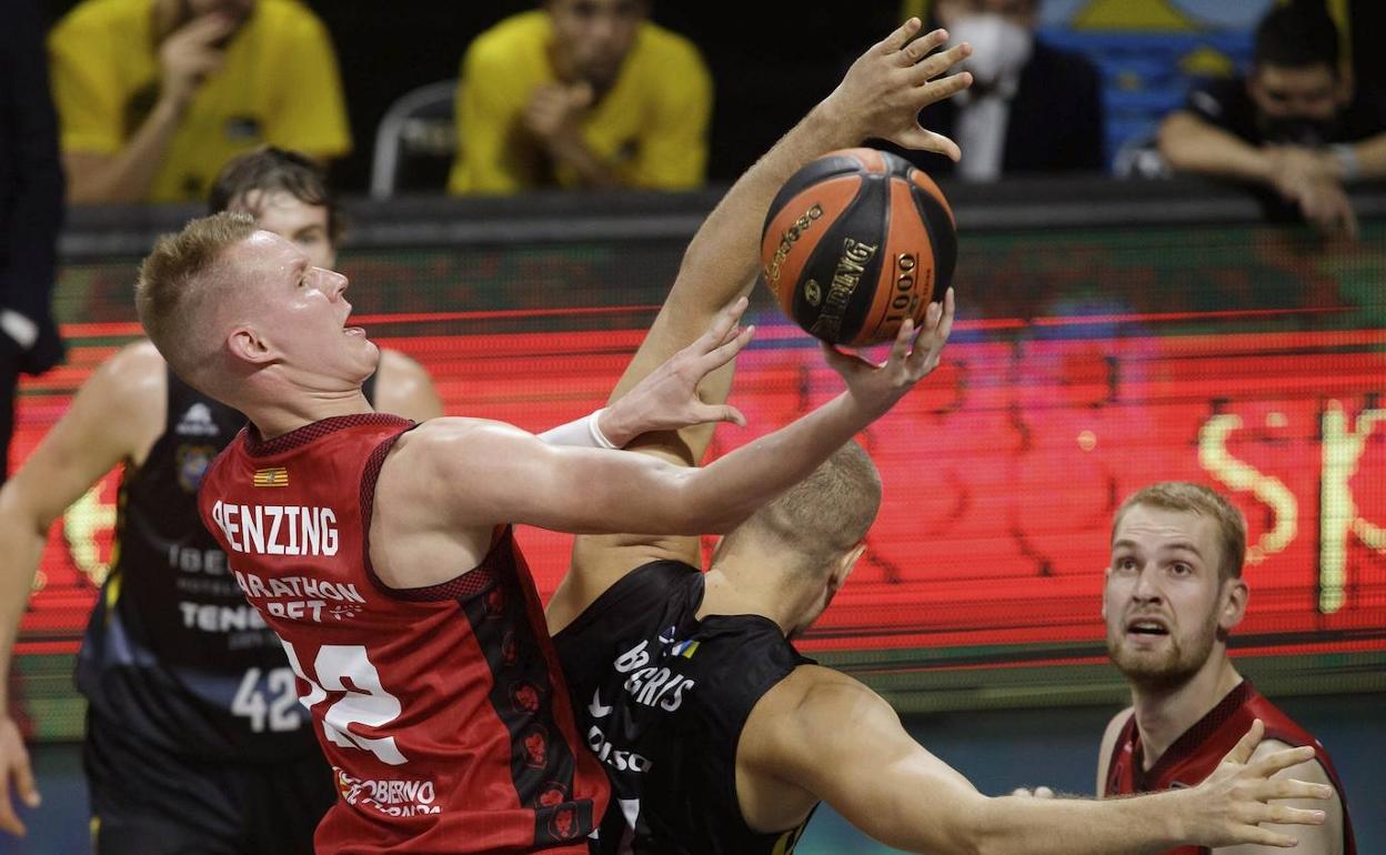 El alero del Casademont Zaragoza Robin Benzing (i) lucha un balón con el griego Georgios Bogris 