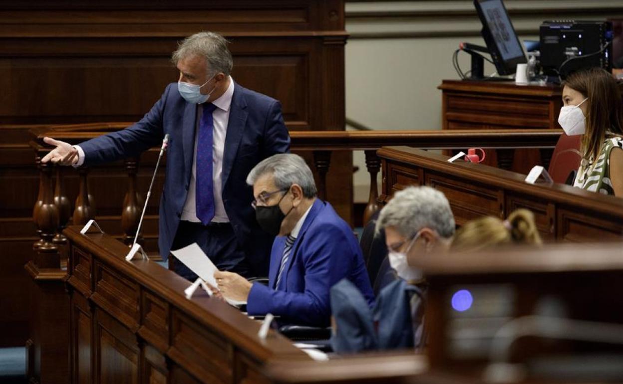 Román Rodríguez, sentado junto a Ángel Víctor Torres en el Parlamento canario este martes.