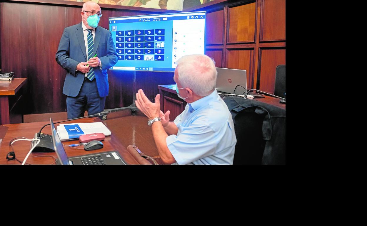 El presidente del Cabildo, Antonio Morales, ante el portavoz de NC, Carmelo Ramírez (sentado), antes del inicio del Debate de la Isla. 