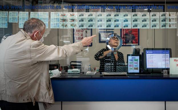 Un cliente elige un número en una administración de loterías. 