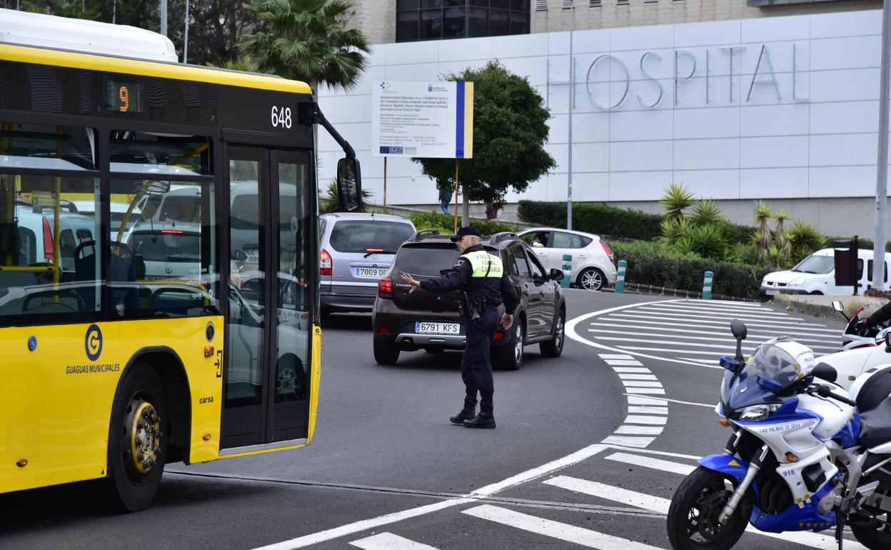 Un agente de la Policía Local regula el tráfico en la rotonda del hospital Doctor Negrín. 