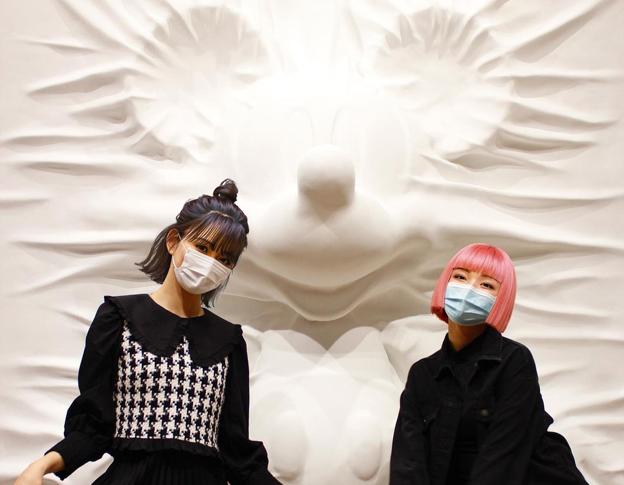 Imma, con el pelo rosa, 'conoce' a otra influencer virtual, Ella, en un museo de Tokio.