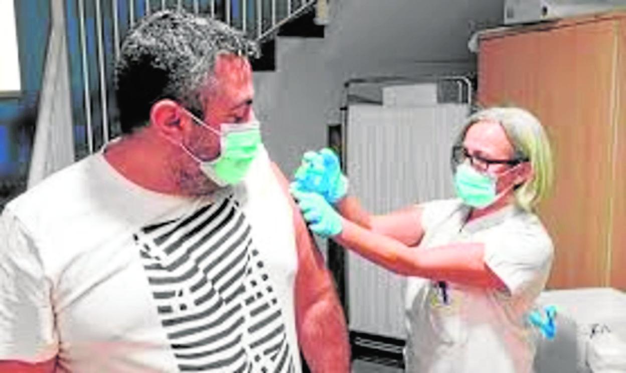 Una sanitaria vacuna a un hombre, en el primer día de la campaña vacunal contra la gripe, en el centro de salud de Alcaravaneras. 