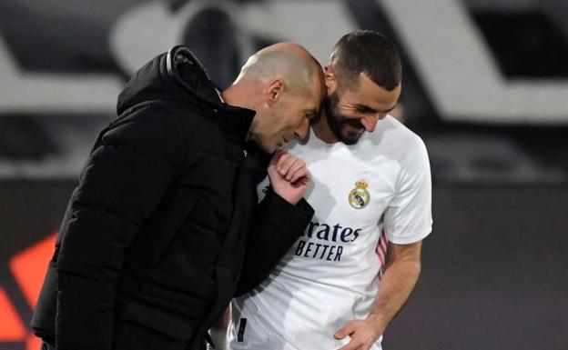 Zinedine Zidane sonríe junto a Karim Benzema. 