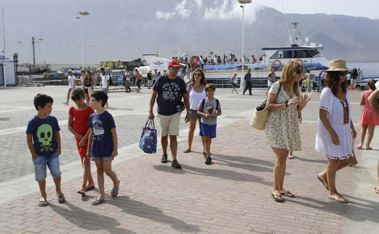 Turistas reciçén desembarcados en la explanada del muelle de La Graciosa. 