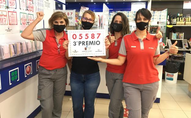 Empleadas de la estación de servicios El Cubillo, en San Juan (Telde), posan con el cartel que acreditan que en este local se vendió el tercer premio de El Niño. 