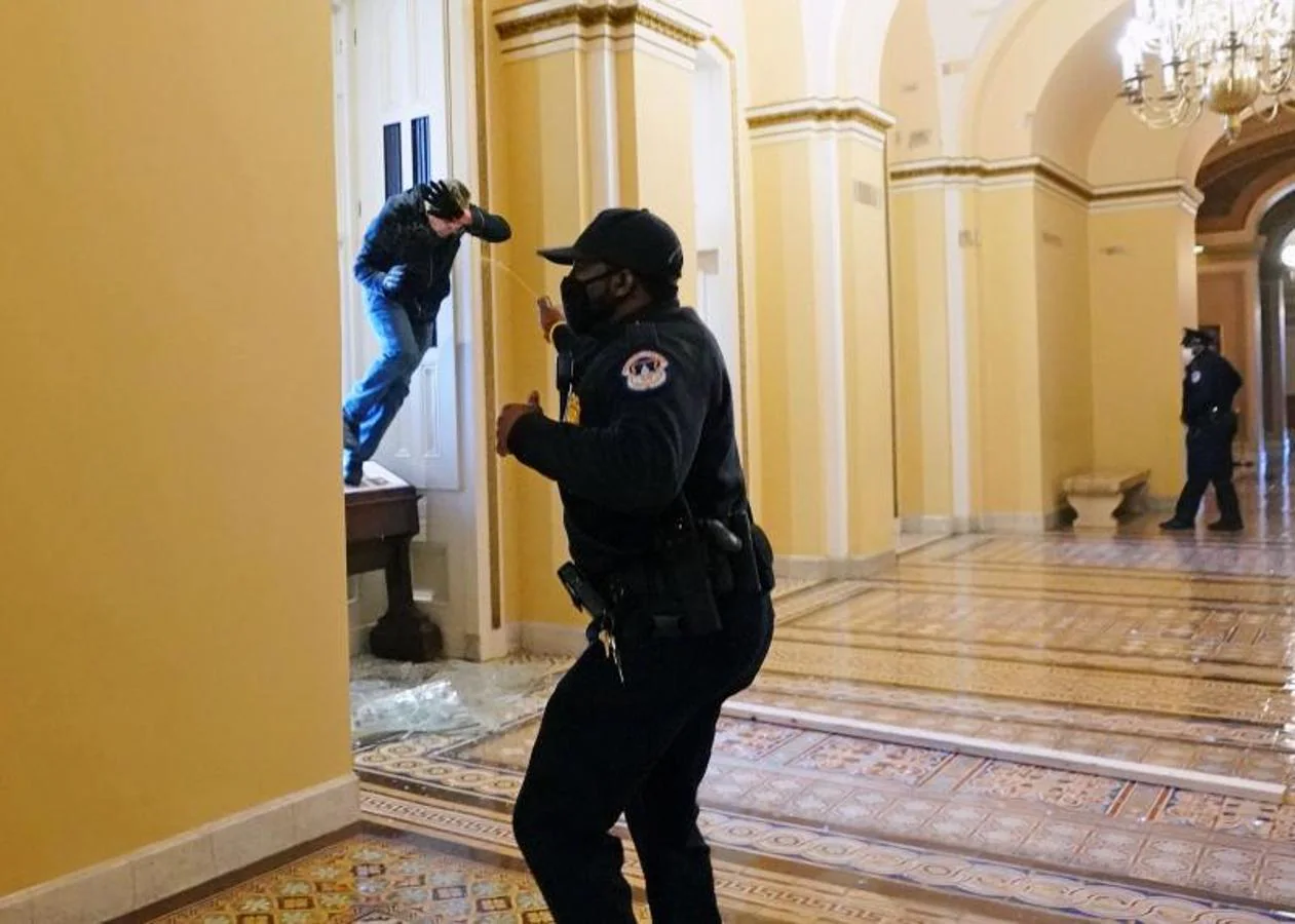 Un oficial de policía del Capitolio dispara gas pimienta a un manifestante