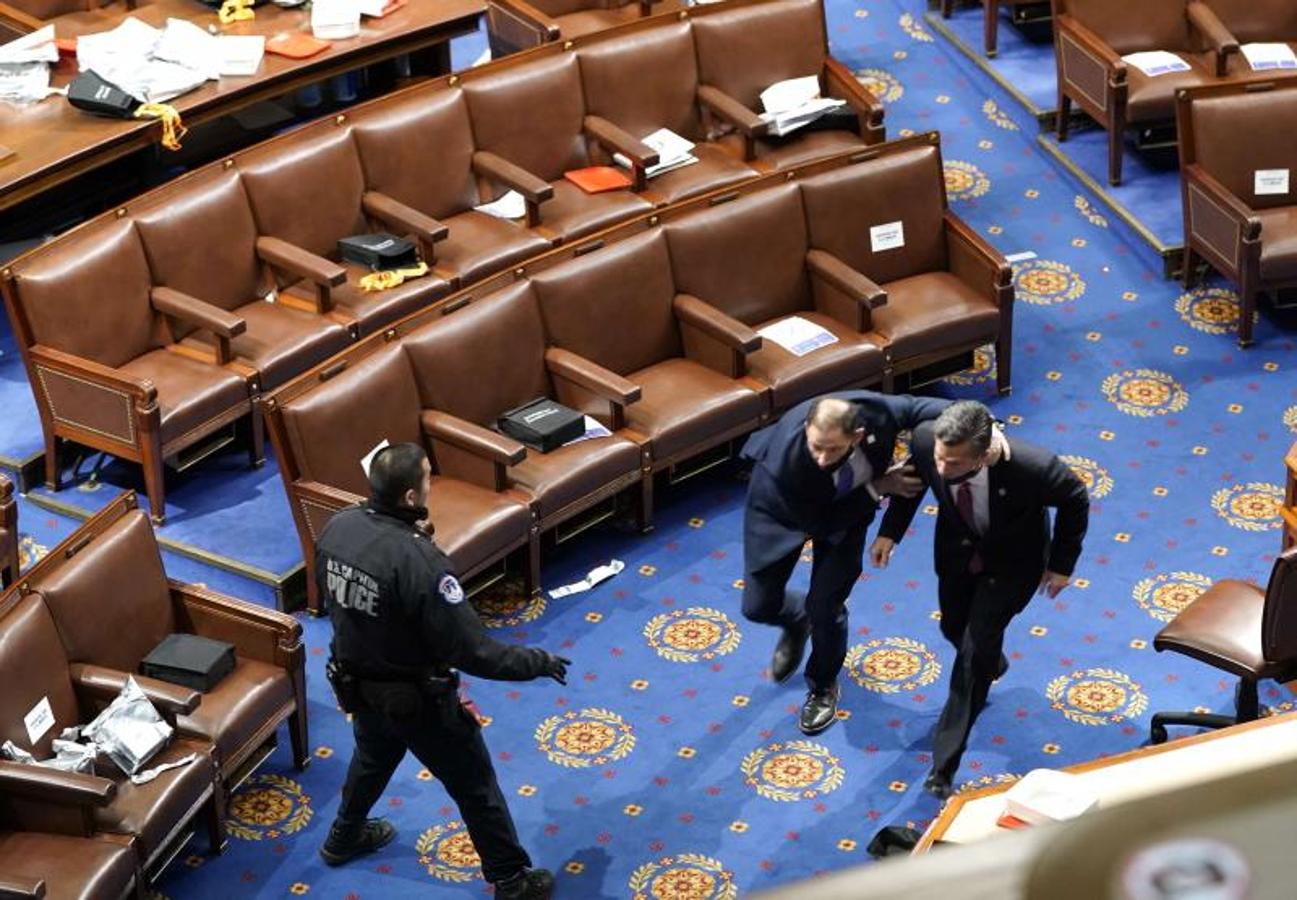 Los miembros del Congreso corren para cubrirse mientras los manifestantes intentan ingresar a la Cámara de Representantes