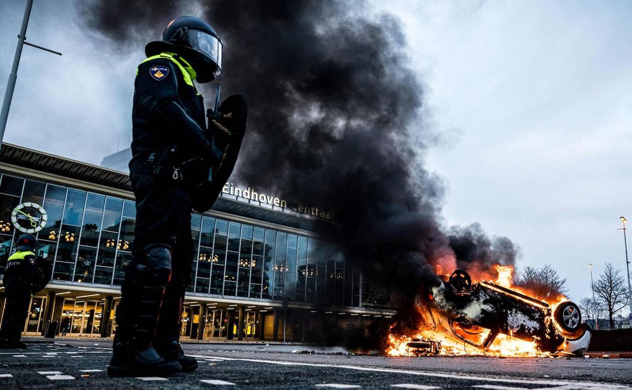 Incendio de un coche de policía en Eindhoven (Países Bajos) durante las protesta contra los toques de queda.