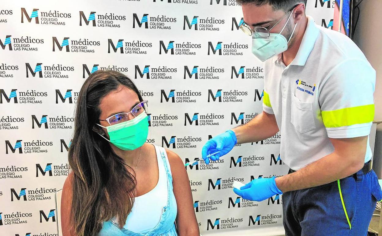 Un sanitario vacuna a una doctora en el Colegio de Médicos de Las Palmas.