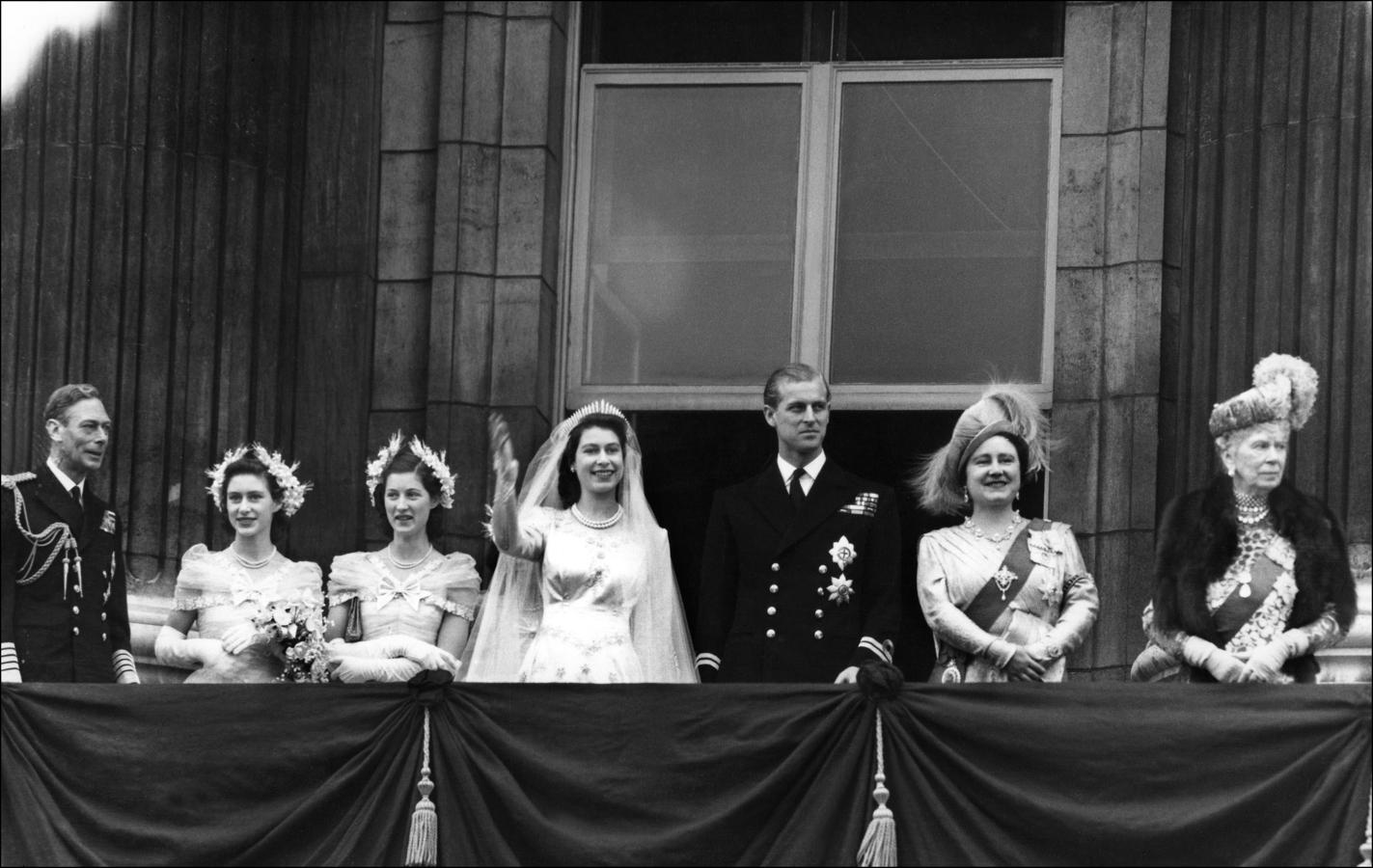 Isabel II y Felipe de Edimburgo saludan desde un balcón del Palacio de Buckingham tras su boda. A la izquierda, el rey Jorge VI.