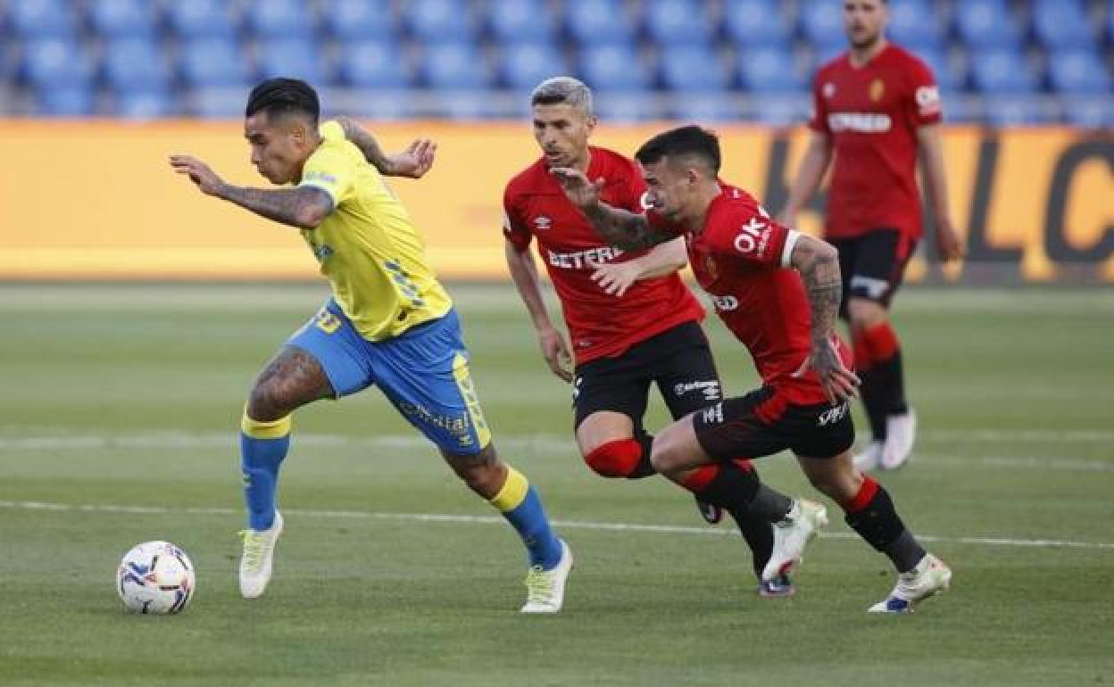 Araujo conduce ante dos defensores del Mallorca. 