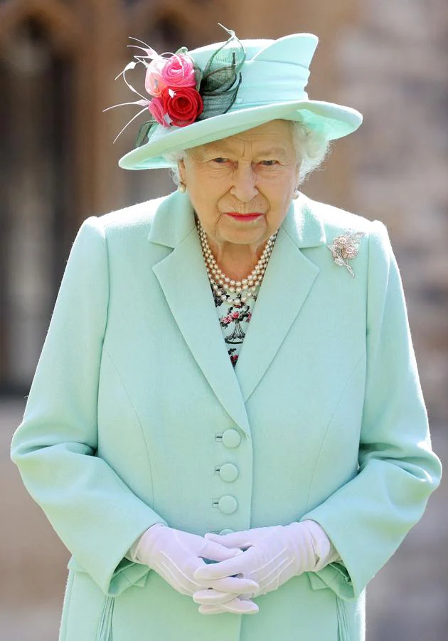 Isabel II posa después de conferir el honor de un título de caballero al veterano capitán Tom Moore, de 100 años, durante una investidura en el Castillo de Windsor, el 17 de julio de 2020.